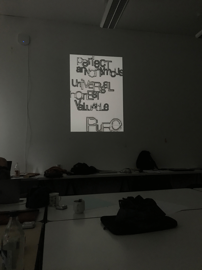 Poster with grey type projeted on a wall by a beamer